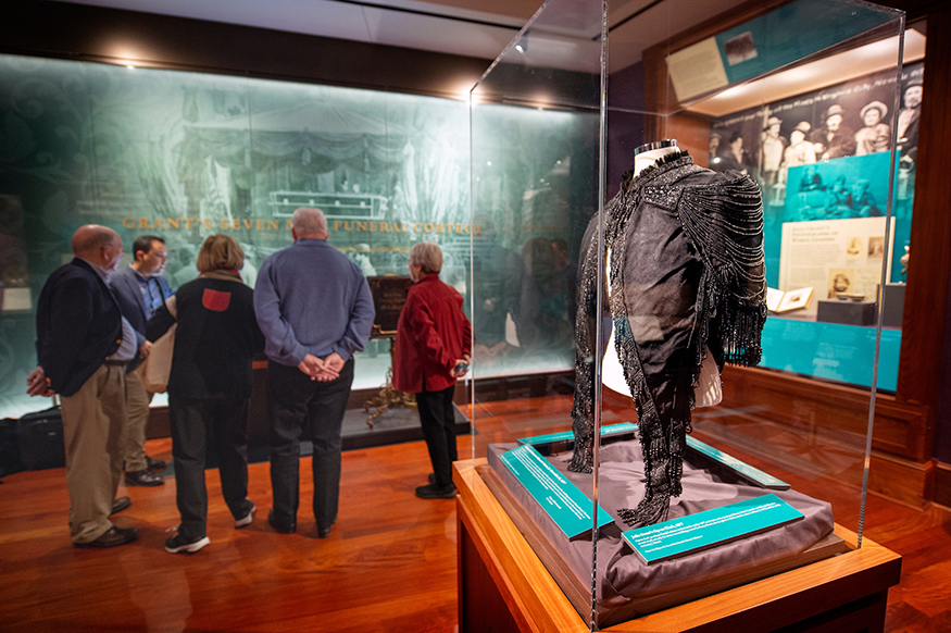 Glass case displaying an opera cloak.