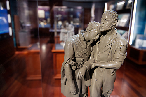 Sculpture of a wounded soldier being helped by a man.